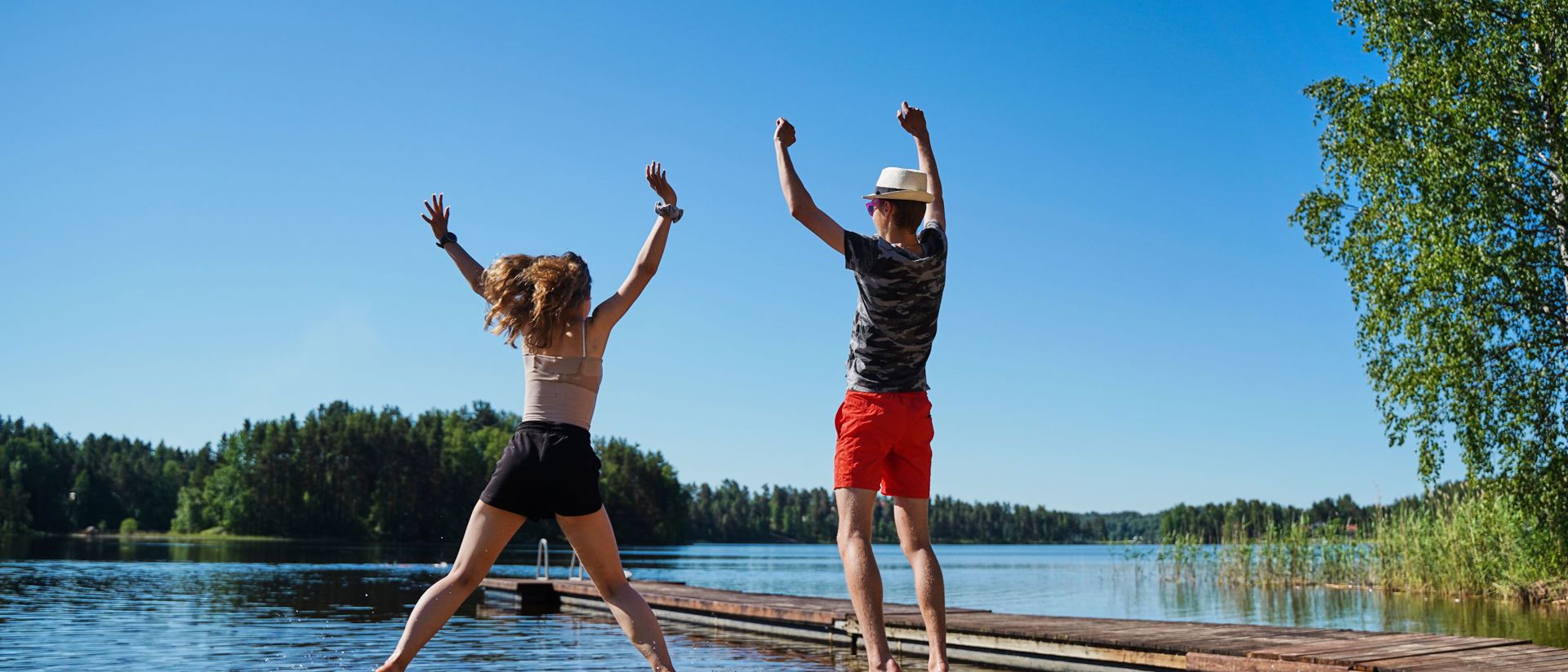 Nuoret hyppää rannalla ilmaan