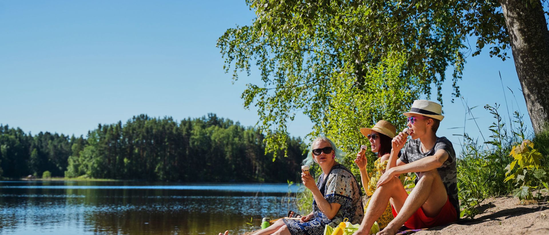 Kolme jäätelönsyöjää rannalla