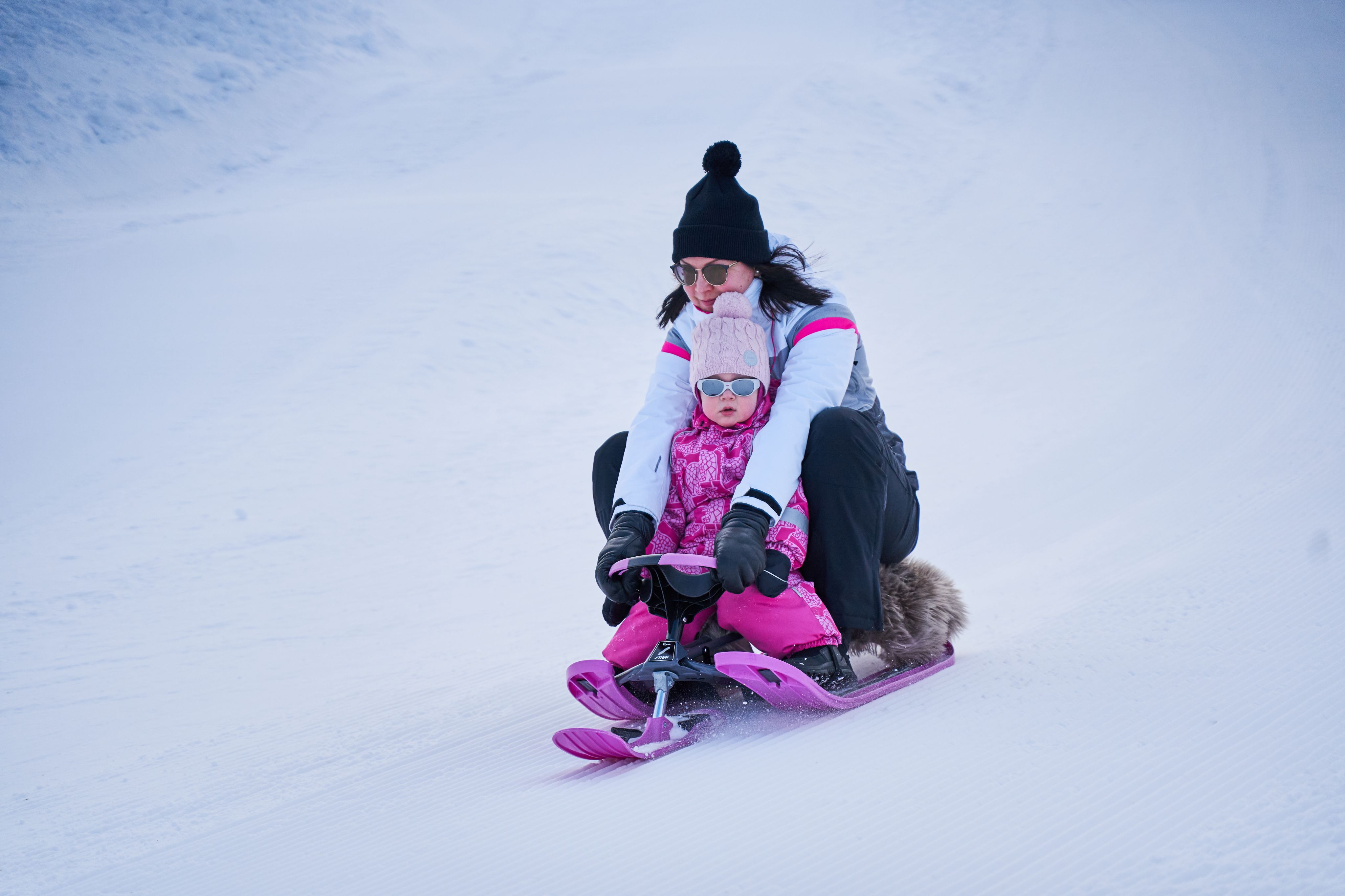 Äiti ja lapsi pulkkamäessä